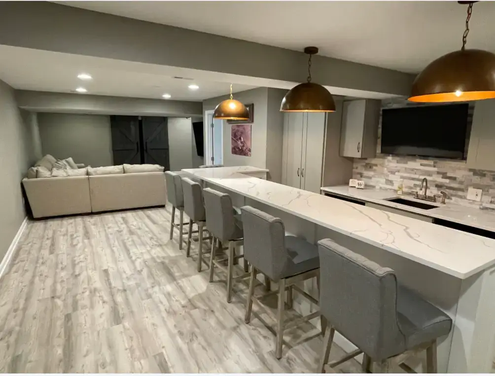 Finished basement Pittsburgh living room with built-in wet bar alcove and plush sectional seating by Pittsburgh Basement Finishing.